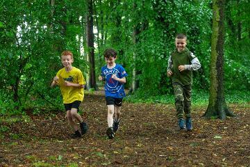 Boys running through the woods at Hardwick Park